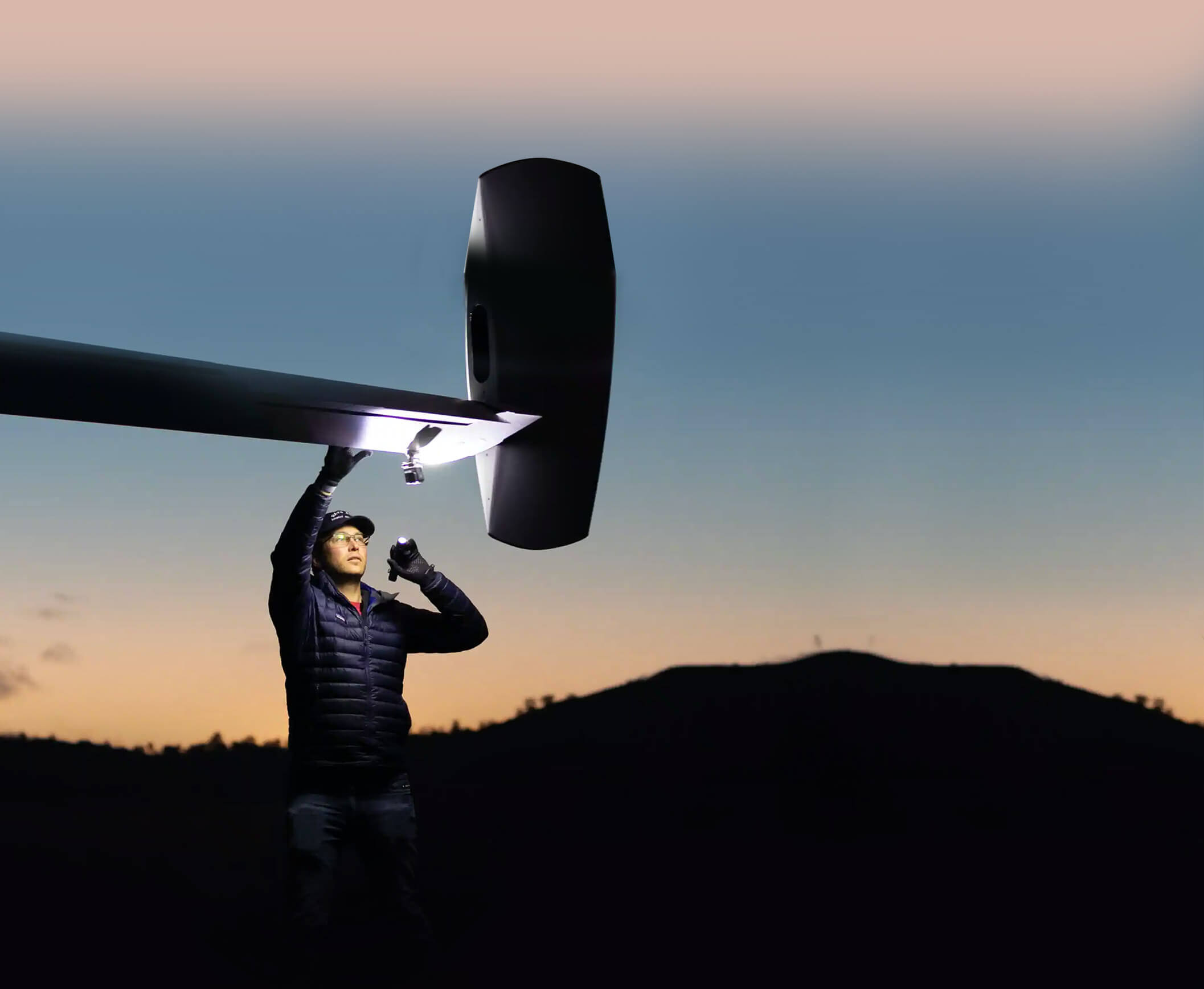 A Man with a Torchlight Checking the Wing of an Airplane